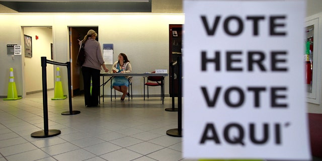 MANSFIELD, TX - NOVEMBER 06: An election official answers a question for a voter on November 6, 2012 in Mansfield, Texas. (Photo by Tom Pennington/Getty Images)