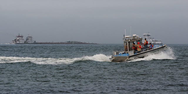 March 22, 2014: A response boat heads to the scene of a collision between a ship and barge in the ship channel near the Texas City Dike. Two workers on one of the vessels were exposed to hydrogen sulfide and decontaminated by the first department at the end of the dike. (AP Photo/The Galveston County Daily News, Neal Mora)