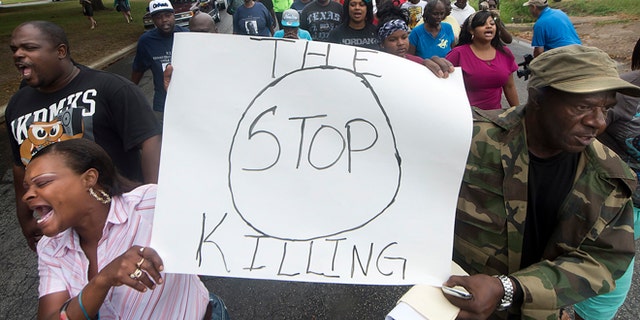 K.K. Davis, left, and Tommy Jones of Hearne carry a sign with other protesters outside the Hearne, Texas police department Thursday, May 8, 2014 following the Tuesday shooting of 93-year-old woman. Robertson County District Attorney Coty Siegert said Pearlie Golden was shot Tuesday night by Officer Stephen Stem. Stem was responding to a 911 call about a disturbance involving a woman with a gun. The Hearne Police Department says Golden "brandished a firearm" when Stem encountered her. He then shot her multiple times. The investigation into the shooting is being handled by the Texas Rangers. (AP Photo/Bryan College Station Eagle, Stuart Villanueva)