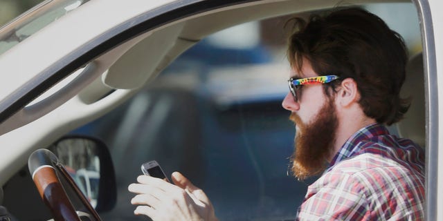 Feb. 26, 2013: A man uses his cell phone as he drives through traffic in Dallas.