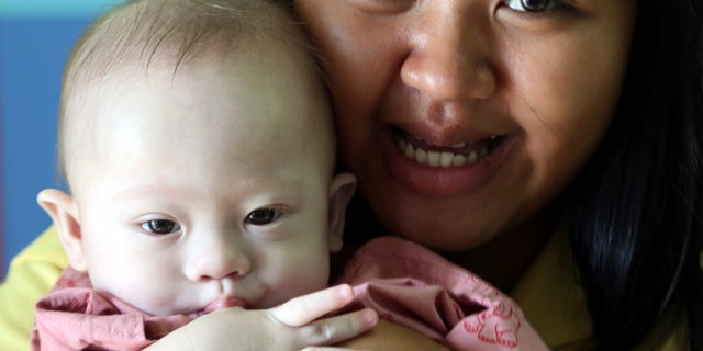 Aug. 3, 2014 - Thai surrogate mother Pattaramon Chanbua, 21, with Gammy, a 9-month old boy born with Down syndrome, at a hospital in Chonburi province, southeastern Thailand. The case of an Australian couple accused of abandoning their baby after discovering he had Down syndrome, has shined light on the unregulated business of commercial surrogacy.