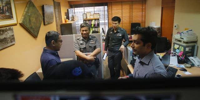 Sunai Phasuk, left, Human Rights Watch’s senior researcher in Asia, and Umesh Pandey, a board member of Foreign Correspondents of Thailand, right, talk to policemen at the Foreign Correspondents Club of Thailand in Bangkok, Thailand Friday, June 26, 2015. Thai authorities on Friday forced the human rights group to cancel the launch of its report on the Vietnamese government’s persecution of an ethnic minority, citing it could affect national security and bilateral relations. Thai police said in a statement Friday the scheduled event at the club could “have an impact on the country’s security or could affect the friendship and cooperation between Thailand and Vietnam.” (AP Photo/Sakchai Lalit)