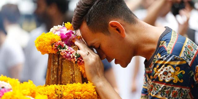 In this Aug. 24, 2015, file photo, a man prays at the Erawan Shrine at Rajprasong intersection, the scene of the Aug. 17 bombing, in Bangkok, Thailand. Thai police probing Bangkok's deadly bombing said on Monday, Aug. 31, 2015, that they have discovered bomb-making materials during a raid of a second apartment on the outskirts of the capital. (AP Photo/Sakchai Lalit, File)