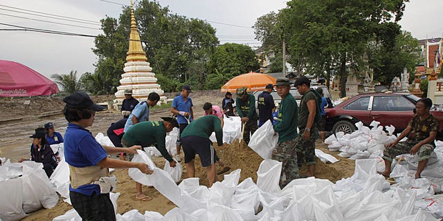 Villagers and soldiers join hands in making sand bags for barricades at a temple in Pak Kred district, Nonthaburi province, Thailand Thursday, Oct. 13, 2011. The ongoing floods is the worst to hit the Southeast Asian nation in decades. About 8.2 million people in 60 of Thailand's 77 provinces have been affected by floods and mudslides, and 30 provinces are currently inundated.