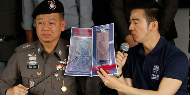 November 17, 2014: Thai police officers show pictures of a tattooed human skin during a press conference at Bangpongpang police station in Bangkok. (AP Photo/Sakchai Lalit)