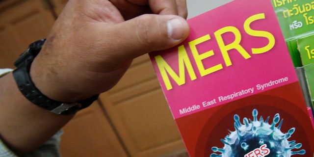 June 18, 2015: A Thai officer takes a flyer after Public Health Minister Rajata Rajatanavin's press conference in Bangkok. Thailand says it has confirmed its first known case of the deadly MERS virus, a man who arrived from a Middle Eastern country for treatment of a heart condition. (AP Photo/Sakchai Lalit)