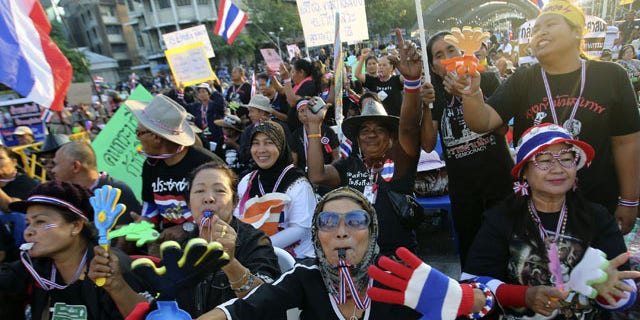 December 1, 2013: Anti-government protesters wave Thai national flags and clapping tools during rally at the Democracy Monument in Bangkok, Thailand. Aggressive political protests in the Thai capital turned violent late Saturday with at least one man killed and several wounded by gunshots in street fighting between supporters and opponents of Prime Minister Yingluck Shinawatra.(AP Photo)