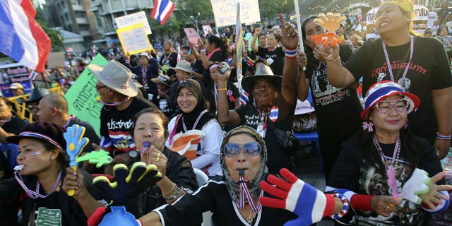 December 1, 2013: Anti-government protesters wave Thai national flags and clapping tools during rally at the Democracy Monument in Bangkok, Thailand. Aggressive political protests in the Thai capital turned violent late Saturday with at least one man killed and several wounded by gunshots in street fighting between supporters and opponents of Prime Minister Yingluck Shinawatra.(AP Photo)