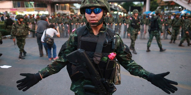 May 26, 2014: A Thai soldier gestures as he and his colleagues guard the Victory Monument during an anti-coup demonstration in Bangkok.(AP Photo/Wason Wanichakorn)