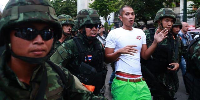 May 24, 2014: A protester is detained by Thai soldiers during an anti-coup demonstration at the Victory Monument in Bangkok. (AP Photo/Wason Wanichakorn)