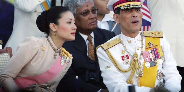 FILE - In this Aug. 31, 2007 file photo, Thailand's Crown Prince Vajiralongkorn, right, chats with his royal consort Princess Srirasm as they watch a parade at the historic Merdeka square in downtown Kuala Lumpur, Malaysia. Thailand's Crown Prince Vajiralongkorn has asked the government to strip his wife's family of their royally issued surname, the latest development in a high-profile crackdown that involves senior members of the police force. The move came after at least three of Princess Srirasm's relatives were arrested as part of the probe. In a letter dated Friday, Nov. 28, 2014 but released over the weekend, the crown prince ordered the "cancellation of the royally bestowed family name 'Akrapongpreecha,'" which was issued after the pair married in 2001. (AP Photo/Vincent Thian, File)