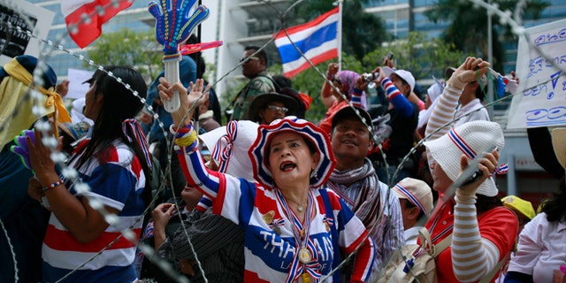 Feb. 19, 2014: Anti-government protesters shout slogans demanding Thai Prime Minister Yingluck Shinawatra to step down during a protest outside her temporary office in the building of the Permanent Secretary of Defense in northern Bangkok, Thailand.