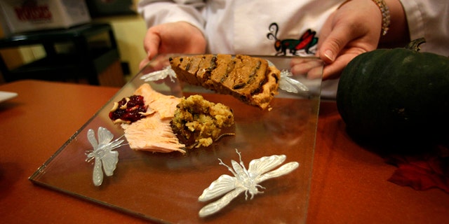 Nov. 11, 2011: Stephanie Smith, an educator at the Audubon Insectarium in New Orleans, shows off a plate of cranberry sauce with wax worms, cricket pumpkin pie, and turkey with cornbread and mealworm stuffing, for visitors to sample Thanksgiving-inspired foods made with insects.