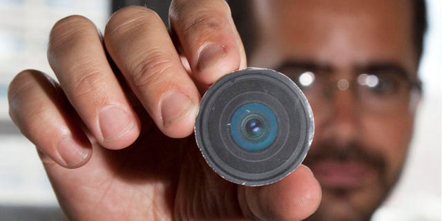 Aug. 24: New York University arts professor, Wafaa Bilal, holding the prototype of a digital camera that he had implanted in the back of his head, in New York.