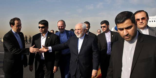 Iran's Foreign Minister Mohammad Javad Zarif, who is also Iran's top nuclear negotiator, center, shakes hands with an official upon arrival at the Mehrabad airport in Tehran, Iran, Wednesday, July 15, 2015. Zarif and his entourage returned to Tehran on Wednesday morning, a day after Iran and the West reached a historic nuclear deal. (AP Photo/Ebrahim Noroozi)