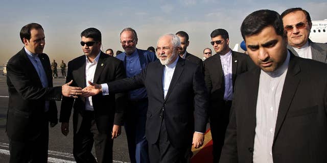 Iran's Foreign Minister Mohammad Javad Zarif, who is also Iran's top nuclear negotiator, center, shakes hands with an official upon arrival at the Mehrabad airport in Tehran, Iran, Wednesday, July 15, 2015. Zarif and his entourage returned to Tehran on Wednesday morning, a day after Iran and the West reached a historic nuclear deal. (AP Photo/Ebrahim Noroozi)