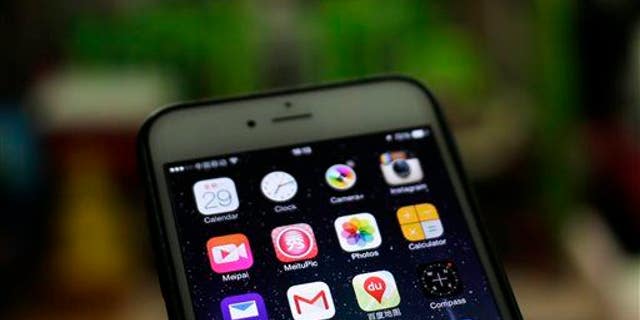 A Gmail mobile app, center left, is seen on a smartphone.