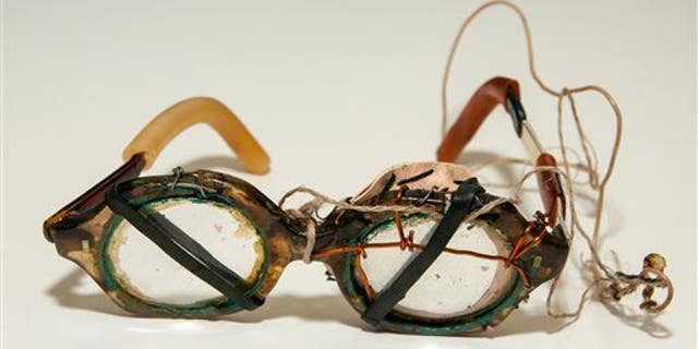 A file photo of eyeglasses held together by string, wire and rubber bands.