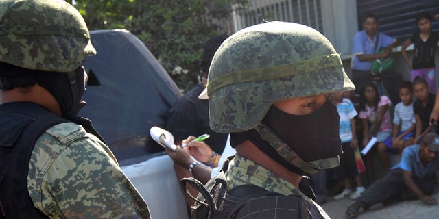 ACAPULCO, MEXICO - MARCH 03: Mexican marines stand guard at the site of a suspected drug-related execution on March 3, 2012 near Acapulco, Mexico. Drug violence has surged in the coastal resort in the last year, making Acapulco the second most deadly city in Mexico after Juarez. One of Mexico's top tourist destinations, Acapulco has suffered a drop in business, especially from foreign tourists, due to the violence. Toursim accounts for about 70 percent of the economy of Acapulco's state of Guerrero and 9 percent of Mexico's economy. (Photo by John Moore/Getty Images)