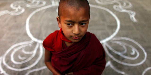 A Tibetan monk stands at a Tibetan Monastery during the third day of "Losar," or Tibetan New Year, at Baudhanath Stupa in Katmandu, Nepal, Friday, Feb. 24, 2012.