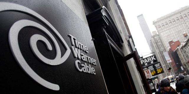 Pedestrians walk past the Time Warner Cable headquarters in New York February 13, 2014. Comcast Corp's proposed $45.2 billion takeover of Time Warner Cable Inc could face close scrutiny from U.S. antitrust regulators because of the deal's potential to reshape the country's pay TV and broadband markets. REUTERS/Joshua Lott (UNITED STATES - Tags: BUSINESS SCIENCE TECHNOLOGY) - RTX18S3F