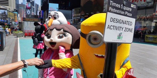 Costumed characters work in New York's Times Square, Tuesday, June 21, 2016.
