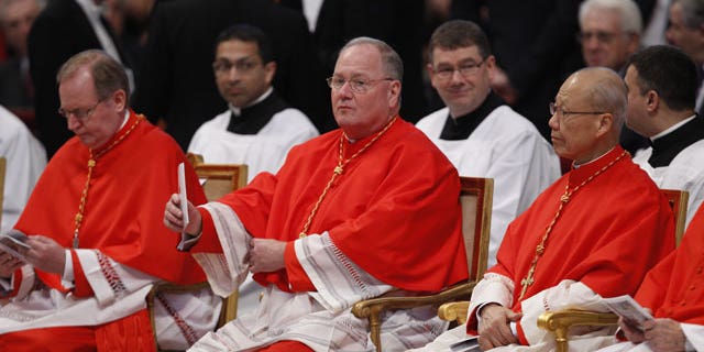 Feb. 18, 2012: Archbishop of New York Timothy Michael Dolan, center, and John Tong, archbishop of Hong Kong, right, sit inside St. Peter's basilica at the Vatican prior to a consistory.