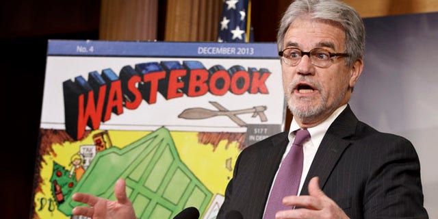 Dec. 17, 2013 file photo, Sen. Tom Coburn, R-Okla., outlines his annual “Wastebook,” which points a critical finger at billions of dollars in questionable government spending during a news conference on Capitol Hill in Washington.