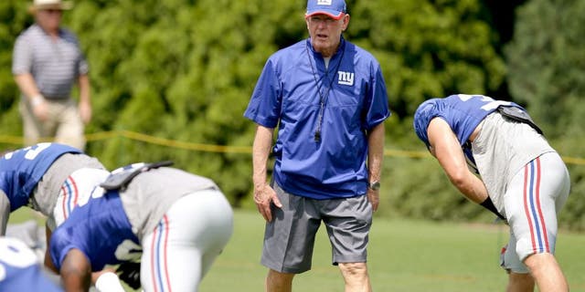 New York Giants coach Tom Coughlin walks the field as his players warm up during NFL football training camp, Tuesday, Aug. 11, 2015, in Cincinnati. (AP Photo/John Minchillo)