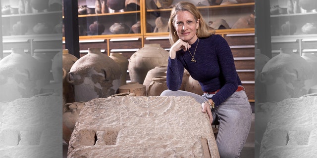 Dr. Katia Cytryn-Silverman, excavation director, standing by the door with carved menorah, at the Collections Hall at the Institute of Archaeology, Hebrew University.