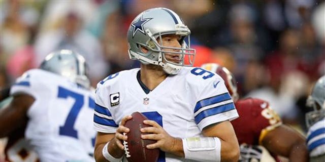 Dallas Cowboys quarterback Tony Romo looks for an opening to pass during the second half of an NFL football game against the Washington Redskins in Landover, Md., Sunday, Dec. 22, 2013. (AP Photo/Evan Vucci)