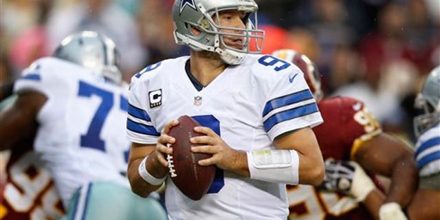 Dallas Cowboys quarterback Tony Romo looks for an opening to pass during the second half of an NFL football game against the Washington Redskins in Landover, Md., Sunday, Dec. 22, 2013. (AP Photo/Evan Vucci)