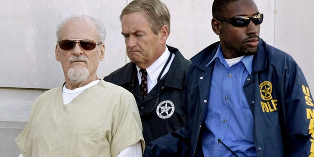 Tony Alamo is escorted to a waiting police car outside the federal courthouse in Texarkana, Ark. on July 23, 2009.