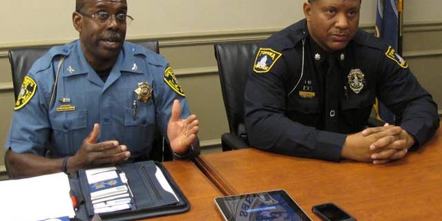 Shawnee County, Kan., Sheriff Herman Jones, left, answers questions from reporters about the shooting death of a Topeka police officer, as interim Police Chief Tony Kirk, right, watches, Sunday, Sept. 7, 2014, in Topeka, Kan. The officer, Cpl. Jason Harwood, 40 was shot during a car stop in east Topeka. (AP Photo/John Hanna)