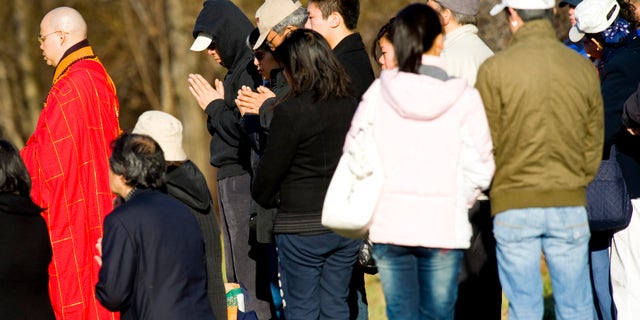 Victim's family members participate in a Buddhist service at the location of a tour bus crash that left fifteen people dead, Saturday, March 19, 2011 in the Bronx borough of New York. Fifteen people were killed March 12, when the bus returning to New York from Connecticut overturned and was split in two by a sign support pole.
