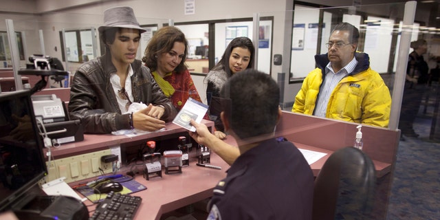 Non-resident visitors to the United States have their passports checked at immigration control after arriving at McCarran International Airport, Tuesday, Dec. 13, 2011, in Las Vegas. The U.S. Travel Association is pushing Congress to make it easier for foreigners to visit the United States. Nearly 7.6 million nonimmigrant visas were issued in 2001, compared to fewer than 6.5 million in 2010.  (AP Photo/Julie Jacobson)