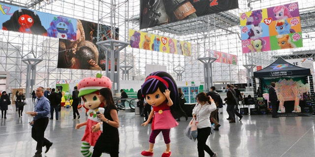 Feb. 16, 2014: Strawberry Shortcake, left, and Cherry Jam, center, walk among people arriving at Toy Fair 2014 at the Jacob K. Javits Convention Center Sunday in New York.