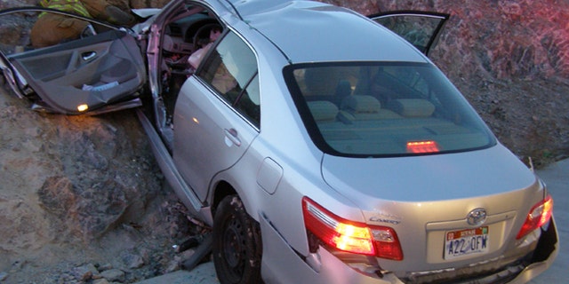 FILE - In this Nov. 5, 2010 file photo released by the Utah Highway Patrol, a Toyota Camry is shown after it crashed as it exited Interstate 80 in Wendover, Utah. Police suspect problems with the Camry's accelerator or floor mat caused the crash that left two people dead and two others injured. The Wall Street Journal is reporting Wednesday March 19, 2014 the U.S. Justice Department may reach a $ 1 billion settlement with Toyota Motor Corp., ending a four-year criminal investigation into the Japanese automaker's disclosure of safety problems. (AP Photo/Utah Highway Patrol, File)