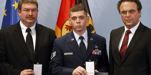 January 16, 2012: Frankfurt airport employee Lamar Joseph Connor, left, from Altha, Florida, and US Staff Sergeant Trevor Donald Brewer, center, from Gray, Tennessee are awarded with The Cross of Merit of the Federal Republic of Germany by German Interior Minister Hans-Peter Friedrich , right, in Berlin, Germany.