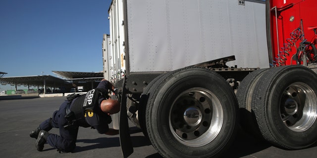 SAN DIEGO, CA - NOVEMBER 14: A U.S. Customs and Border Protection inspects a truck coming from Mexico into the United States at the Otay Mesa port of entry on November 14, 2013 in San Diego, California. Otay Mesa is the second busiest cargo port in the southwestern United States, with some 750,000 trucks passing through annually. (Photo by John Moore/Getty Images)