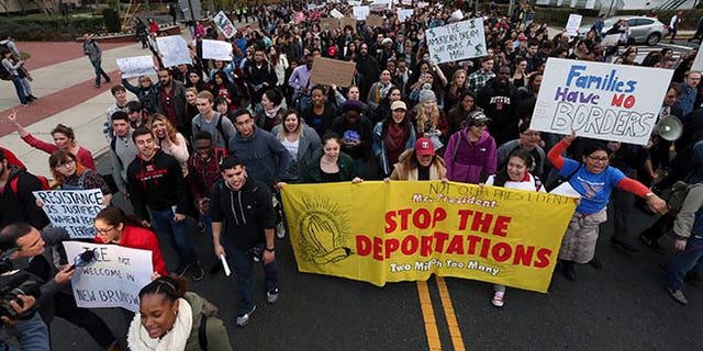 Hundreds of Rutgers University students block College Ave., in New Brunswick, N.J., as they march to protest some of President elect Donald Trump's policies and to ask school officials to denounce some of his plans at Rutgers University Wednesday, Nov. 16, 2016, in New Brunswick, N.J. College students at campuses around the United States say they are planning rallies and walkouts to call on school administrators to protect students and employees against immigration proceedings under Donald Trump's presidency. (AP Photo/Mel Evans)