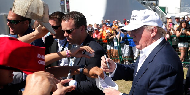 GOP presidential candidate Donald Trump signs autographs during the final round of the Cadillac Championship golf tournament, Sunday, March 6, 2016, in Doral, Fla. (AP Photo/Wilfredo Lee)