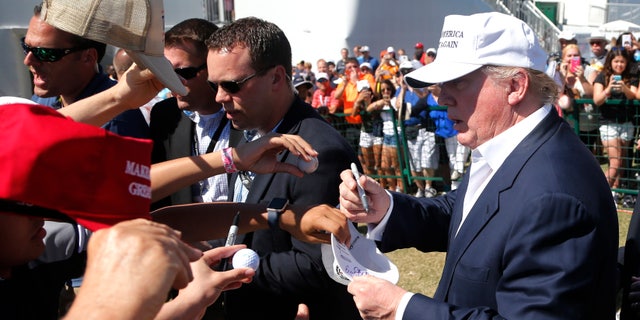 GOP presidential candidate Donald Trump signs autographs during the final round of the Cadillac Championship golf tournament, Sunday, March 6, 2016, in Doral, Fla. (AP Photo/Wilfredo Lee)