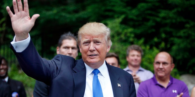 Republican presidential candidate Donald Trump waves as he arrives at a house party in Bedford, New Hampshire, June 30, 2015. (AP Photo/Jim Cole, File)