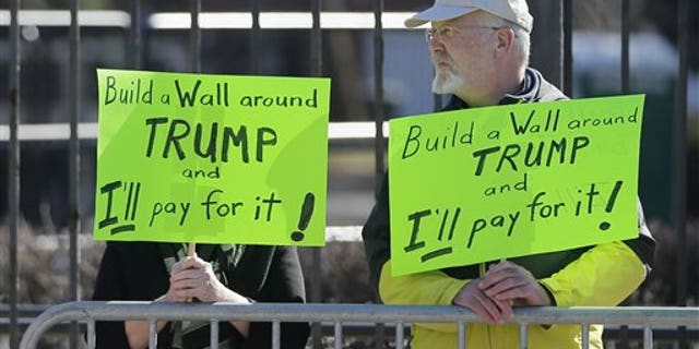 Two protesters of Republican presidential candidate, Donald Trump stand outside on the University of Illinois-Chicago campus before a Trump rally,, Friday, March 11, 2016, in Chicago. (AP Photo/Charles Rex Arbogast)