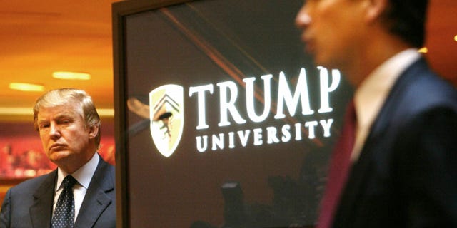 FILE- In this May 23, 2005 file photo, real estate mogul and Reality TV star August 25, 2013: Donald Trump, left, listens as Michael Sexton introduces him at a news conference in New York where he announced the establishment of Trump University. New York Attorney General Eric Schneiderman is suing Trump for $40 million, saying that “Trump University” didn’t deliver on its advertised promise to make students rich, but instead steered them into expensive yet mostly useless seminars. (AP Photo)