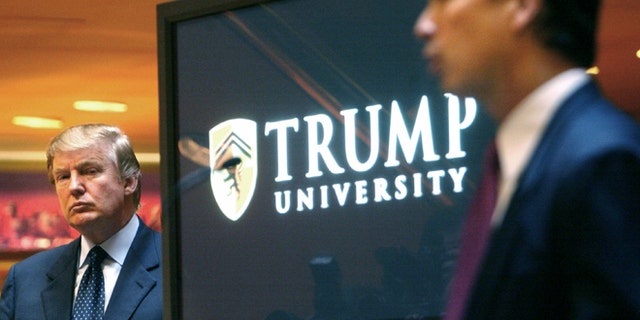 FILE- In this May 23, 2005 file photo, real estate mogul and Reality TV star Donald Trump, left, listens as Michael Sexton introduces him at a news conference in New York where he announced the establishment of Trump University. A federal judge who has been a target of Donald Trumps unending scorn must decide whether to release videos of the presumed Republican presidential nominee testifying in a lawsuit about the now-defunct Trump University, images that Trumps attorneys worry will be used to tarnish the campaign. (AP Photo/Bebeto Matthews, File)
