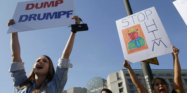 Women hold up signs protesting Donald Trump outside of the Hyatt Regency hotel before the California Republican Party 2016 Convention in Burlingame, Calif., Friday, April 29, 2016. (AP Photo/Jeff Chiu)