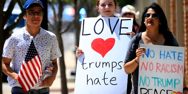 DALLAS, TX - JUNE 16: Protestors walk before Republican presidential candidate Donald Trump's rally on June 16, 2016 at Gilley's in Dallas, Texas. Trump arrived in Texas on Thursday with plans to hold rallies and fundraisers. (Photo by Ron Jenkins/Getty Images)