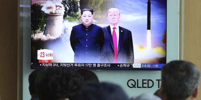 People watch a TV screen showing file footage of U.S. President Donald Trump, right, and North Korean leader Kim Jong Un during a news program at Seoul Railway Station in Seoul, South Korea.